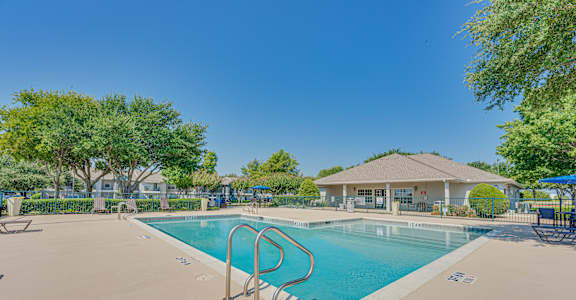 A large outdoor swimming pool with a diving board.