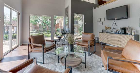A modern living room with brown leather chairs and a glass coffee table.
