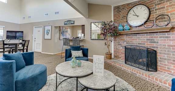 A living room with a fireplace and a clock on the wall.