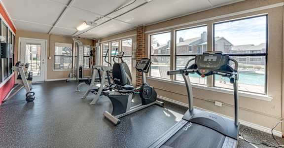 A gym with treadmills, weights, and exercise equipment.