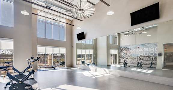 A gym with a treadmill, exercise bike, and other equipment.