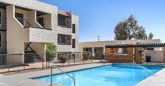 a swimming pool is in front of an apartment building