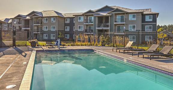 A large apartment complex with a pool in front at GATEWAY BY VINTAGE, 98387