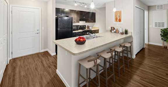 Summerset Affordable Apartments A kitchen with a bar area and stools.
