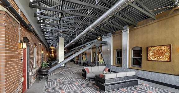 the lobby of a building with couches and a rug at The Knights @ 506 Delaware Apartments, Buffalo, 14202