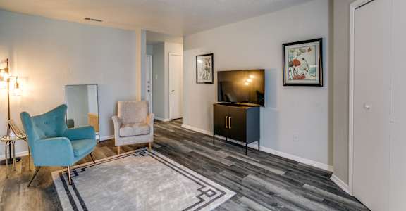 A living room with a blue chair and a grey sofa.