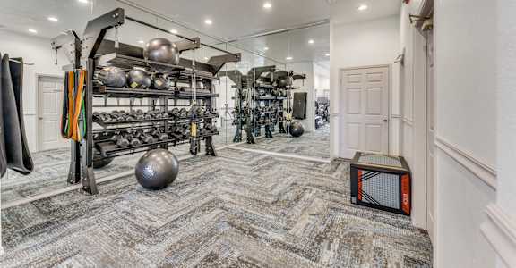 a workout room with weights and equipment and a door to a closet