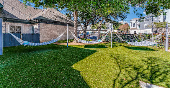 a yard with hammocks in the yard of a house
