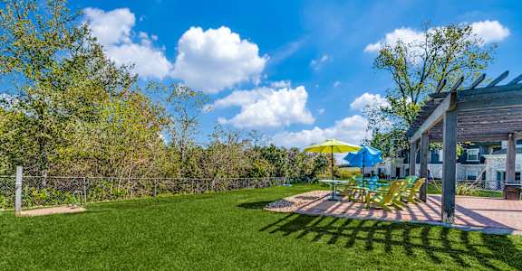 a backyard with a patio with chairs and umbrellas