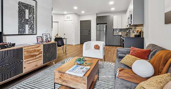 A modern living room with a grey couch and a wooden coffee table.
