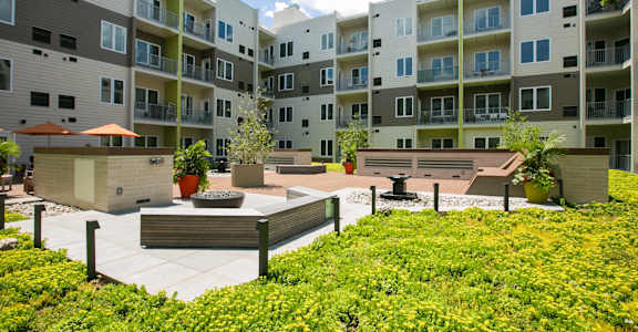 an apartment building with a patio and a fire pit