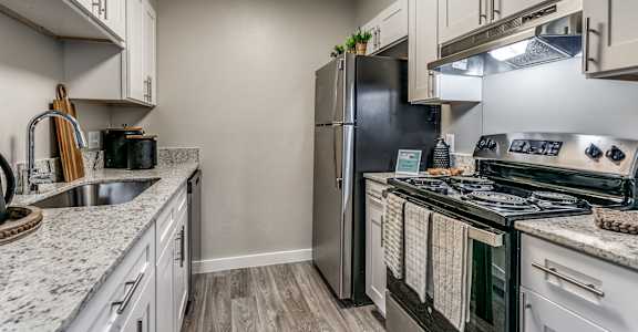 an updated kitchen with stainless steel appliances and granite counter tops