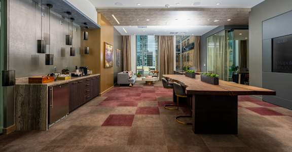 A modern office space with a long wooden table and chairs.