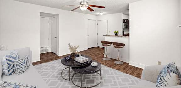 A living room with a white couch, a coffee table, and a ceiling fan.