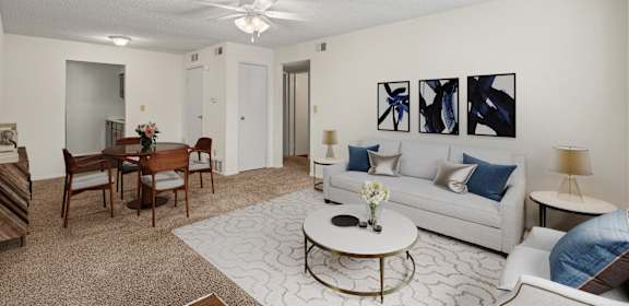 A living room with a white couch, a coffee table, and a painting on the wall.