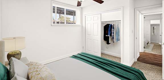 A bedroom with a bed, a ceiling fan, and a closet.