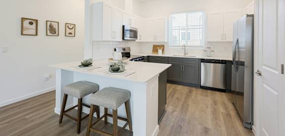 A kitchen with a white island and stools.