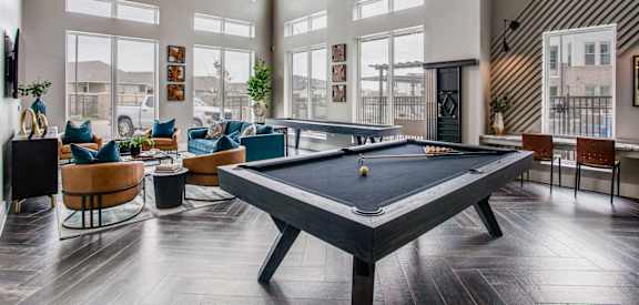a pool table in the clubhouse at the bradley braddock road station apartments