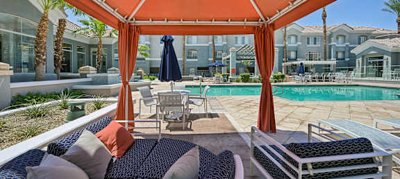 A patio with a pool and a canopy.