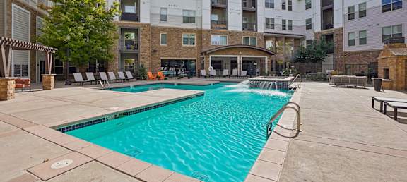 A large swimming pool surrounded by apartment buildings.