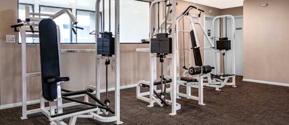 a gym with weights and a punching bag in the corner of a room