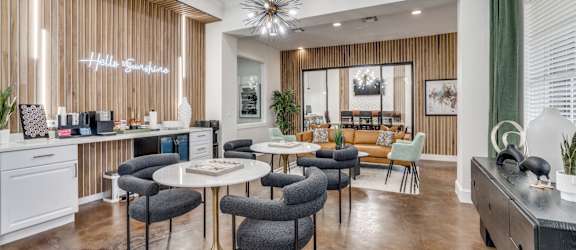a living room with tables and chairs and a kitchen