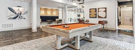 a pool table in a clubhouse with a chandelier