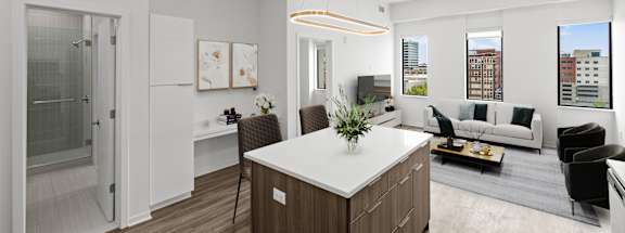 A modern kitchen with a white island and wooden floors.