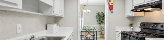 A kitchen with white cabinets and a black stove top oven.