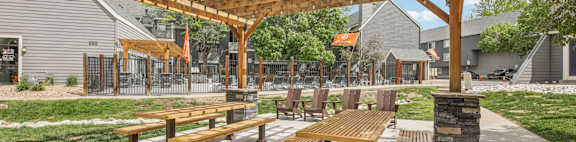 A wooden pergola with benches is in the foreground of the image.