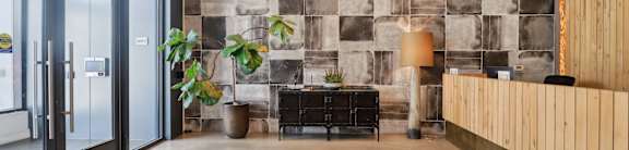 A reception area with a stone wall and a wooden panel.