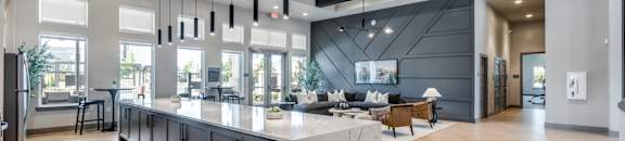 A modern kitchen with a marble island and wooden floors.