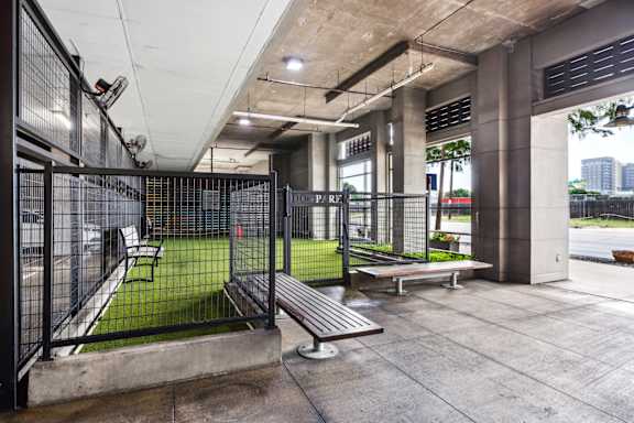 A modern outdoor seating area with a metal fence and benches.