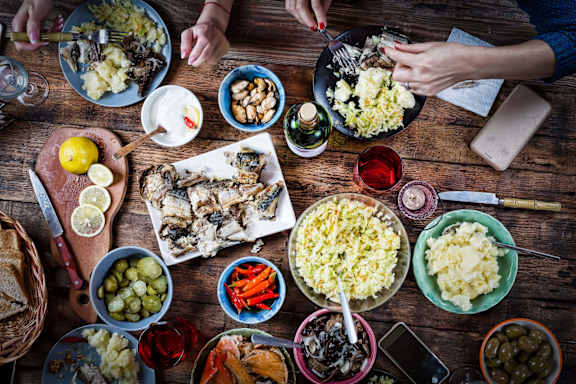 A table full of food with people eating.