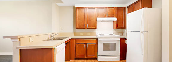 A kitchen with wooden cabinets and white appliances.