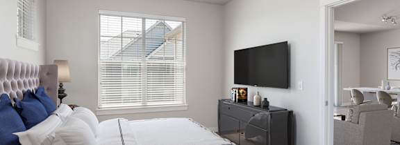 A patio with a black sofa and a TV mounted on the wall.
