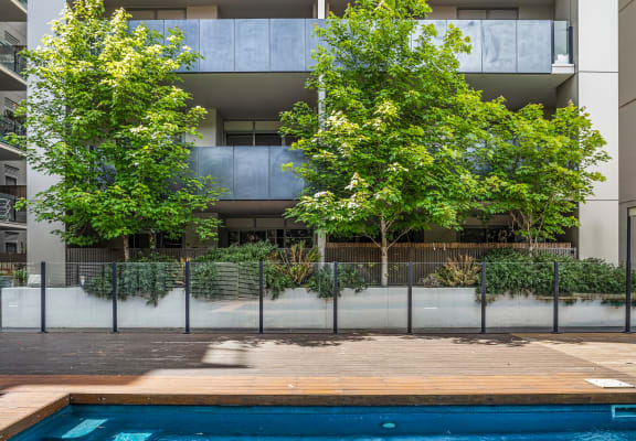 a swimming pool in front of a building with trees