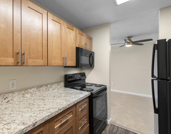 a kitchen with granite countertops and black appliances  at Park Edmonds Apartment Homes, Edmonds, WA