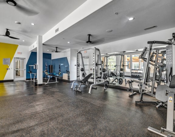 a gym with exercise equipment and a yellow and blue wall at Urban Crest Apartments, San Antonio, TX, 78209