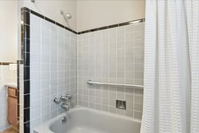 a bathroom with white tiles and a white shower curtain