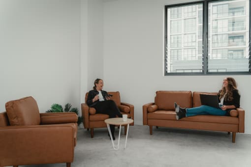 two women sitting on couches in a living room