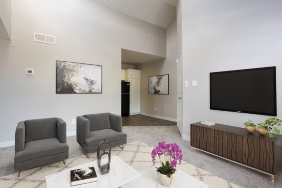 a living room with two chairs a television and a table