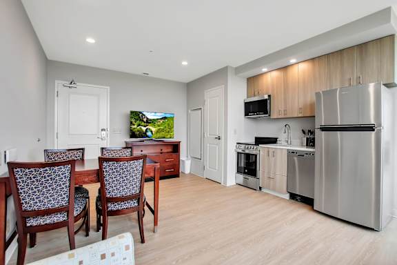 A modern kitchen with a TV mounted above the counter.