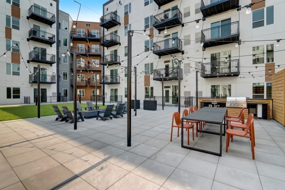 an outdoor patio with a table and chairs at the bradley braddock road station apartments