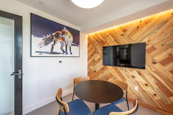 A room with a wooden wall and a TV mounted on it.
