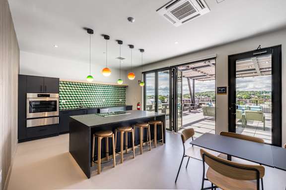 A modern kitchen with a bar area and a view of the outdoors.
