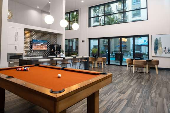 A pool table is in the middle of a room with a TV and a fireplace.
