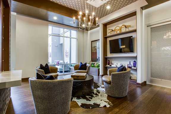 A living room with a grey sofa and a black and white cowhide rug.