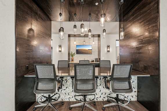 A modern office with a wooden floor and a long table with four chairs at The Stadler Luxury Apartments, Florida 34210