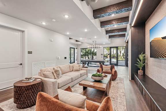 A modern living room with a large couch, a coffee table, and a fireplace at The Stadler Luxury Apartments, Bradenton, FL 34210